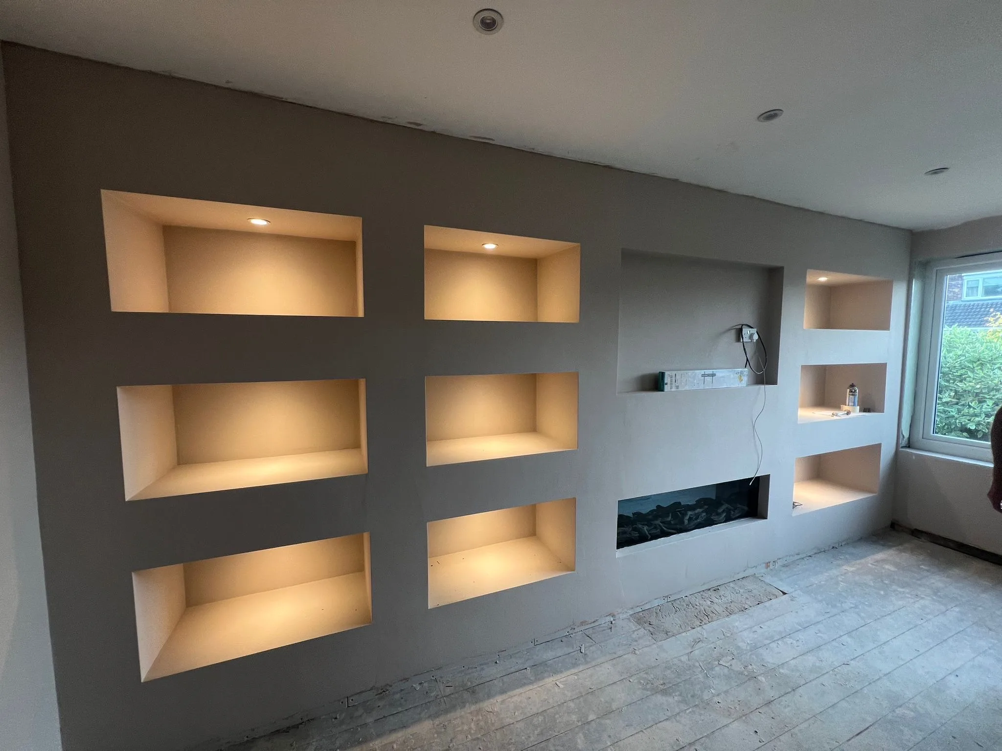 Full-width media wall with LED lit niches and fireplace by LDG Joinery LTD