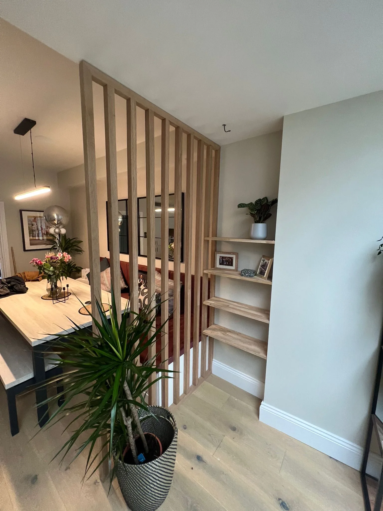 Bespoke slatted oak room divider with integrated shelving by LDG Joinery LTD