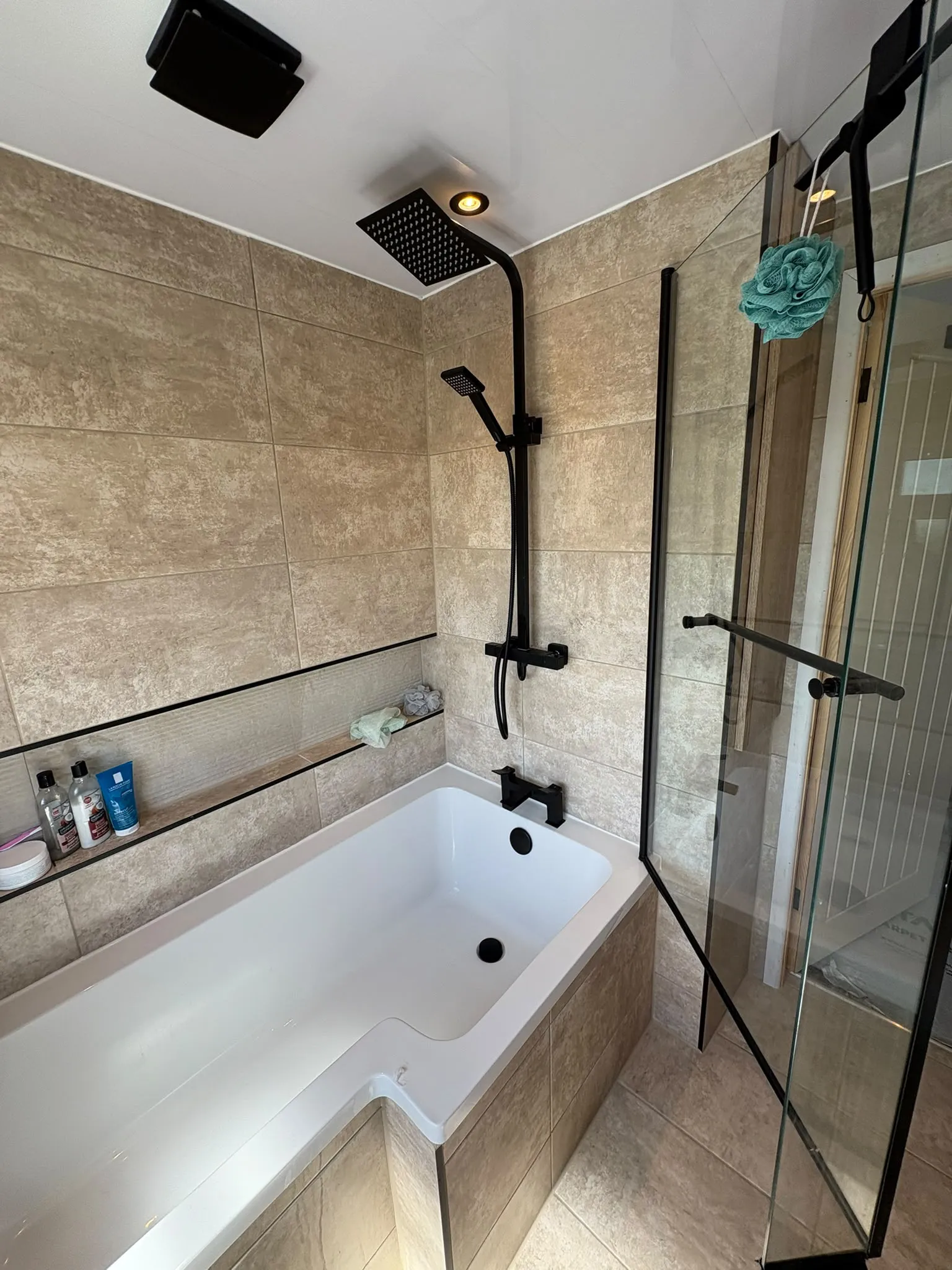 Fitted bathroom with matte black shower fittings and stone-effect tiling by LDG Joinery LTD, Bolton